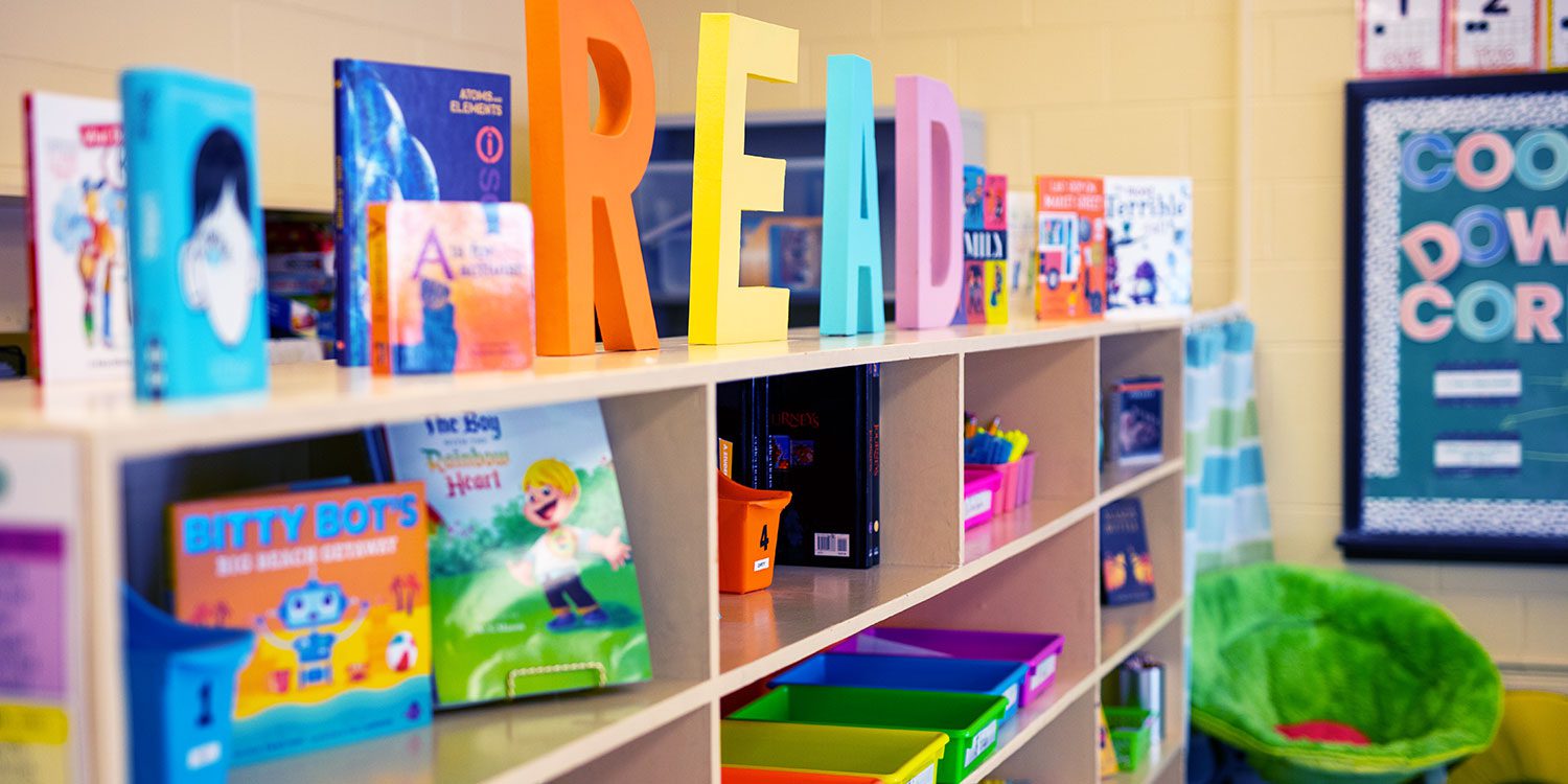Reading corner with bookshelf of materials and comfortable chair.