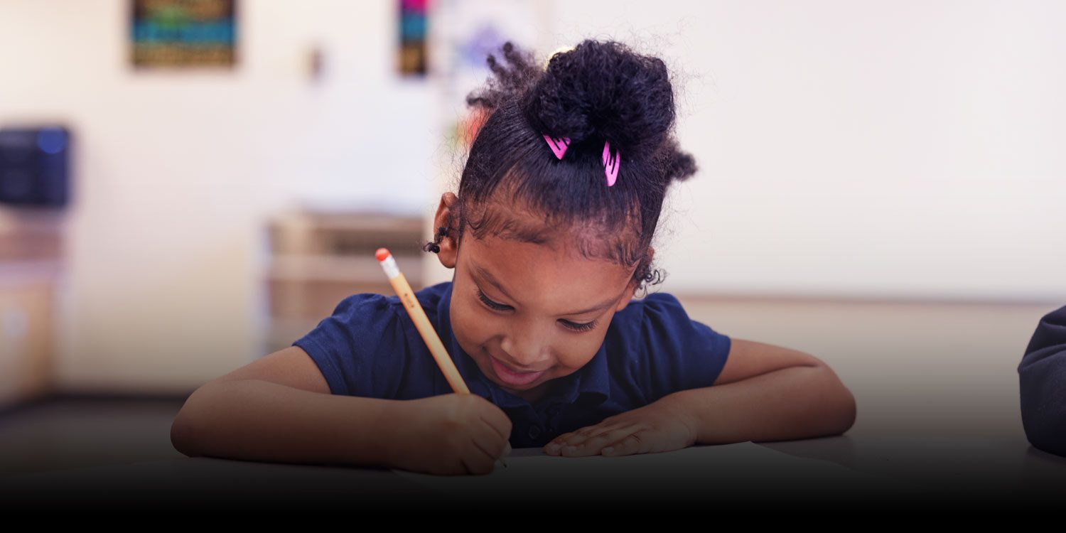 A smiling student working on an assignment